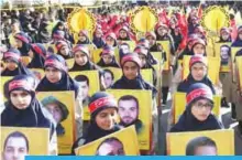  ?? — AFP ?? NABATIEH, Lebanon: Members of Lebanon’s Shiite Hezbollah scout movement hold portraits of Hezbollah fighters killed while fighting in Syria during a procession.