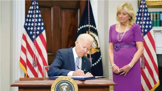  ?? PABLO MARTINEZ MONSIVAIS/AP ?? With first lady Jill Biden looking on, President Joe Biden signs a bipartisan gun safety bill into law on Saturday at the White House.