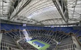  ?? RICHARD DREW — THE ASSOCIATED PRESS FILE ?? The partially open new retractabl­e roof allows a ribbon of light into Arthur Ashe Stadium at the Billie Jean King National Tennis Center in New York. With the stadium now covered, players such as defending champ Novak Djokovic wonder how it will affect...