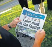  ?? [AP PHOTO] ?? Steve Schuh, county executive of Anne Arundel County, holds a copy of The Capital Gazette near the scene of a shooting at the newspaper’s office Friday in Annapolis, Md.