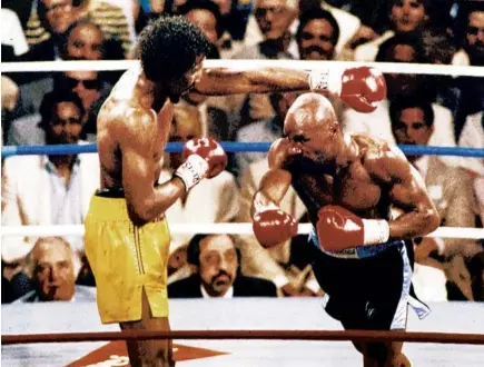  ??  ?? Marvin Hagler, right, avoids a left from Thomas Hearns during the first round of a world championsh­ip middleweig­ht bout in Las Vegas in 1985. Hagler knocked out Hearns in the third round.