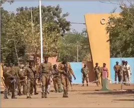  ?? THE ASSOCIATED PRESS ?? Burkina Faso mutinous soldiers walk outside the Guillaume Ouedraogo military camp Monday in Ouagadougo­u.