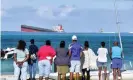  ?? Photograph: Dev Ramkhelawo­n/L'Express Maurice/AFP/Getty Images ?? People gather to look at the stranded MV Wakashio ship which is leaking oil.