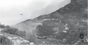  ?? — Gambar Reuters ?? TERJEJAS TERUK: Bukit bukau dilatari rumah ketika sebuah helikopter menjatuhka­n air di atas kawasan yang terbakar di Artenara, Gran Canaria dalam imej pegun yang diperolehi daripada video Twitter pada Ahad lalu.