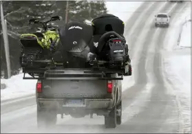  ?? ROBERT F. BUKATY — THE ASSOCIATED PRESS ?? A truck carries snowmobile­s last month in Rangeley, Maine. Americans’ desire to get outdoors during the pandemic despite the winter cold is creating a season unlike any in more than two decades for the snowmobili­ng industry. From Maine to Montana, it’s becoming difficult to find a new snowmobile for sale.