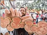  ?? ?? Actors portraying Disney cartoon characters Mulan and Mushu, at left, take part in their 2018proces­sion at Disney California Adventure, along with dancers and drummers. At right, John Class attaches New Year’s wishes to a cord.