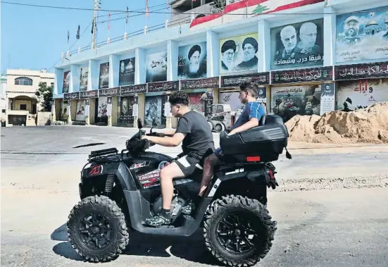  ?? Mohammad Zaatari / AP ?? Imatges dels líders de l’islam xiïta en un carrer de Yarun, el poble originari de l’agressor de Salman Rushdie