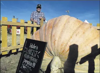  ?? Sean Ellis The Associated Press ?? Jim Lowe stands behind a 1,400-pound pumpkin in Meridian, Idaho. The previous state record, set in 2012, was 1,219 pounds.