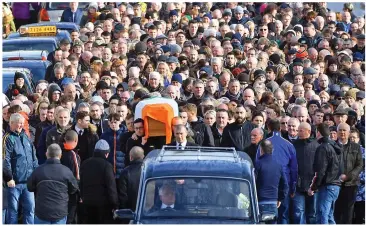  ??  ?? Procession: Martin McGuinness’s coffin is carried through Londonderr­y yesterday