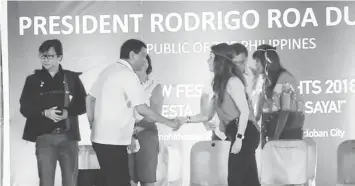  ?? MIRIAM G. DESACADA ?? President Duterte shakes hands with Tacloban City Mayor Cristina Romualdez on stage at the start of the Sangyaw Festival program, after the Parade of Lights.