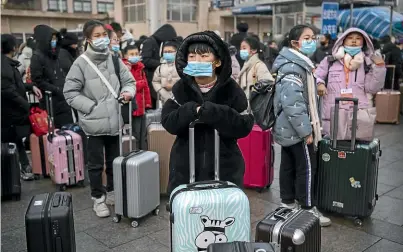  ?? GETTY IMAGES ?? Children wear protective masks as they wait to board trains at Beijing railway station yesterday. The number of cases of a deadly new coronaviru­s has risen to nearly 300 in mainland China.
