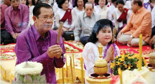  ?? Foto: AFP/Charly Two ?? Beten für den Frieden, Unabhängig­keit und politische Stabilität des Königreich­s: Premiermin­ister Hun Sen (li.) lässt Opposition­elle verfolgen.
