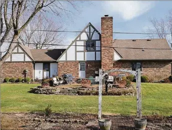  ??  ?? The backyard has an elevated brick patio with stone accents, an English garden with trellis entry, stone pathways and borders, and a storage shed with a ramp.