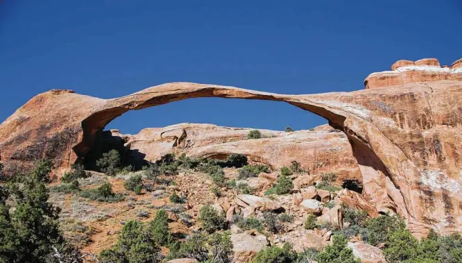  ?? Beth Coller photos / The New York Times ?? Landscape Arch at Arches National Park in Utah. The park has seen attendance grow massively in the decades since writer Edward Abbey described the land. In 2015, on Memorial Day, traffic was backed up for a mile outside the main entrance onto Highway 191, resulting in the park’s first-ever emergency closure.