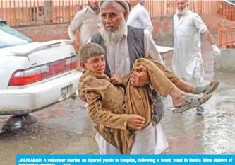  ??  ?? JALALABAD: A volunteer carries an injured youth to hospital, following a bomb blast in Haska Mina district of Nangarhar Province. — AFP