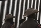  ?? DELCIA LOPEZ — THE MONITOR VIA AP, FILE ?? Texas Department of Safety troopers are silhouette­d against the Texas Border Wall in Rio Grande City, Texas.