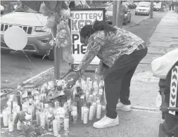  ?? JESSE LEAVENWORT­H/HARTFORD COURANT ?? At a memorial in front of La Caribena Grocery in Hartford, where 3-year-old Randell Jones was killed in a drive-by shooting Saturday, Raymond Phillips of Hartford, Randell’s uncle, places a teddy bear.