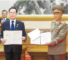  ??  ?? South Korea’s then-Defense Minister Song Young-moo, left and North Korean Minister of the People’s Armed Forces No Kwang-chol show reporters the Comprehens­ive Military Agreement signed by the two with presence of President Moon Jae-in and North Korea’s leader Kim Jong-un in this Sept. 19, 2018, file photo. Joint Press Corps