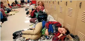  ??  ?? Emily Hindle lies on the floor at an evacuation shelter set up at Rutherford High School, Panama City Beach, in advance of Hurricane Michael.