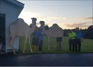  ?? KEITH REYNOLDS — THE MORNING JOURNAL ?? Members of the Breath of Heaven Committee pose with wooden camels Sept. 14 at their new location St. Matthew Lutheran Church, 15617 Mason Road in Vermilion. One of the camels lost a leg during the move.