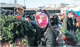  ?? Foto: AP ?? Ante la necesidad de cubrirse y la escasez de mascarilla­s en el mercado, una persona usa una máscara de snorkel como precaución.