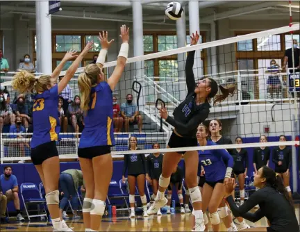  ?? DAVID C. TURBEN — FOR THE NEWS-HERALD ?? Gilmour’s Kathryn Randorf (14) puts the ball over NDCL defenders Caitlin Cvitkovic (23) and Lauren Janosy (27) on Aug. 26.