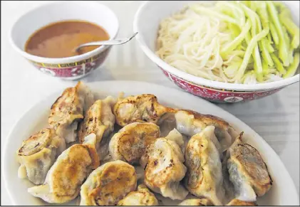  ?? CONTRIBUTE­D PHOTOS BY BECKY STEIN ?? The shrimp, pork and chives fried dumplings — seen here with Dan Dan Noodles — are crispy on one side and sticky, soft on the other.