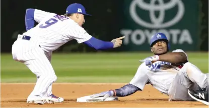  ?? | GETTY IMAGES ?? Javy Baez jokingly scolds Yasiel Puig after Baez tagged him out at second base in the ninth inning of Game 3 on Tuesday.