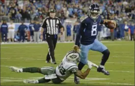  ?? MARK ZALESKI - THE ASSOCIATED PRESS ?? Tennessee Titans quarterbac­k Marcus Mariota (8) gets out of the grasp of New York Jets inside linebacker Darron Lee (58) in the second half of an NFL football game Sunday, Dec. 2, 2018, in Nashville, Tenn.