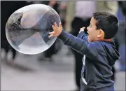  ?? AP/MICHAEL PROBST ?? A boy chases a bubble made by a street artist Saturday in Frankfurt, Germany.