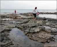  ?? CHUSNUL CAHYADI/JAWA POS ?? POTENSI BARU: Seorang turis menyusuri bebatuan alami di Pantai Kerrong. Wabup Qosim melihat daerah wisata untuk rencana pengembang­annya.