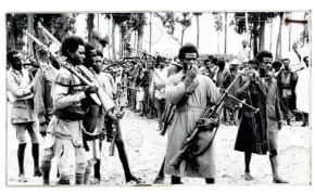  ??  ?? Tungt bevaebnet med erobrede italienske våben samler etiopiere sig i Addis Abeba for at høre meddelelse­n om kejser Haile Selassies tilbageven­den den 5. maj 1941.