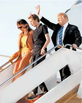  ??  ?? El matrimonio Trump y su hijo Barron, a su llegada a Florida.