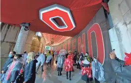  ??  ?? Visitors hide in the tunnel to escape the steady rainfall during Ohio State University’s spring commenceme­nt at Ohio Stadium on Sunday.