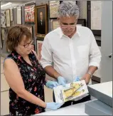  ?? Arkansas Democrat-Gazette/CARY JENKINS ?? Jo Ellen Maack and Bill Gatewood of the Old State House Museum check out old programs from the Arkansas State Fair.