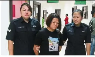  ??  ?? Facing the law: Li being led away after she was denied bail at the Magistrate’s Court in Kuching.