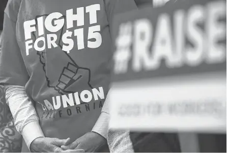  ?? ALEX WONG/ GETTY IMAGES ?? An activist wears a “Fight For $ 15” T- shirt before a vote on the Raise the Wage Act at the U. S. Capitol in 2019. The legislatio­n would raise the federal minimum wage from $ 7.25 to $ 15 by 2025.