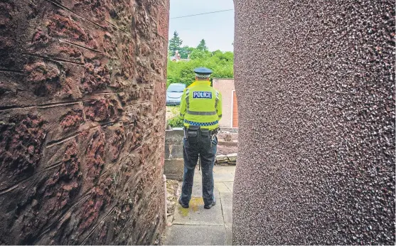  ?? Picture: Steve Macdougall. ?? A police officer on Marywell Brae, Kirriemuir, as investigat­ions continue into the death of Steven Donaldson.