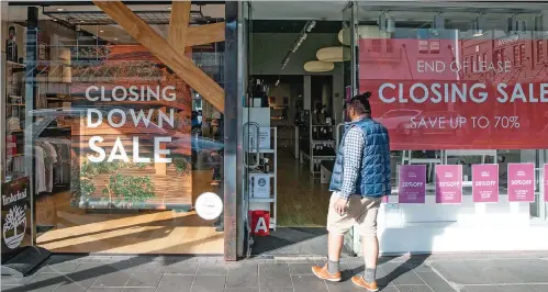  ?? (AFP) ?? A shopper makes his way into a store offering a closing down sale in Auckland. (File photo)