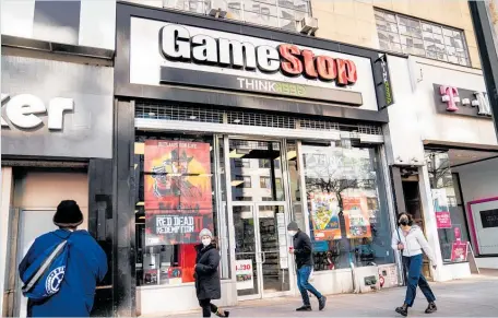  ?? Photos / AP ?? Pedestrian­s pass a GameStop store on 14th Street at Union Square in Manhattan, New York.