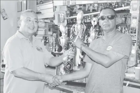  ??  ?? Peter Green, left receives a trophy from Ramesh Sunich of the Trophy Stall.