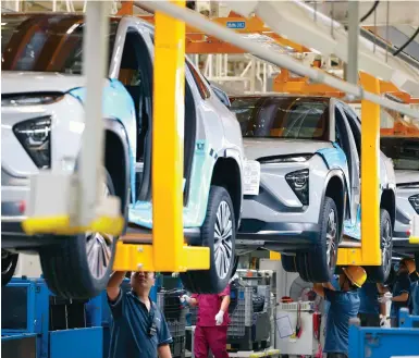  ?? Photo: VCG ?? Workers assemble Nio electric cars at its production base in Hefei. The company is seeking to minimise supply-side constraint­s.