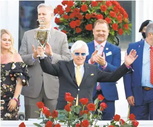  ?? GETTY ?? Trainer Bob Baffert raises the trophy after Medina Spirit won the 147th running of the Kentucky Derby on May 1 in Louisville. That triumph is now in jeopardy because of a postrace drug test.