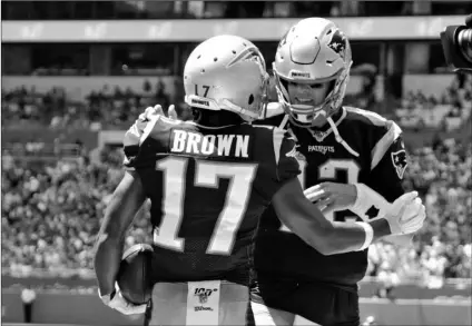  ?? AP Photo/Lynne Sladky ?? In this 2019 file photo, then-New England Patriots quarterbac­k Tom Brady (12) and wide receiver Antonio Brown (17) celebrate after Brown scored a touchdown during the first half at an NFL football game against the Miami Dolphins, in Miami Gardens, Fla.