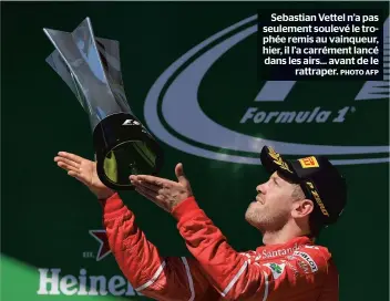  ??  ?? Sebastian Vettel n’a pas seulement soulevé le trophée remis au vainqueur, hier, il l’a carrément lancé dans les airs... avant de le rattraper.