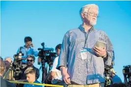  ?? JAY FLEMING/EPA-EFE ?? Pat Furgurson, right, reporter of the Capital Gazette, reports outside the scene of a shooting that took the lives of five of his colleagues and injured at two others.