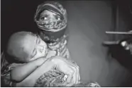  ?? WONG MAYE-E/AP PHOTO ?? M’s daughter, right, hands over her baby brother to their mother in their shelter in Kutupalong refugee camp in Bangladesh on June 26. “M” was raped by six soldiers from Myanmar’s security forces after they strangled her 2-yearold son to death. She...