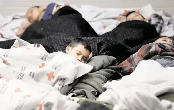  ?? Eric Gay / Associated Press ?? Detainees sleep in a holding cell Wednesday at a Customs and Border Protection facility in Brownsvill­e.