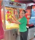  ?? NADIA CANTÚ/LA VOZ ?? Sylvia Molina, general manager of America Cinemas, serves popcorn.