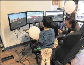  ?? CONTRIBUTE­D ?? Children work on a flight simulator at an open house at Decatur’s 21st Century STEM Academy, which opens this fall.